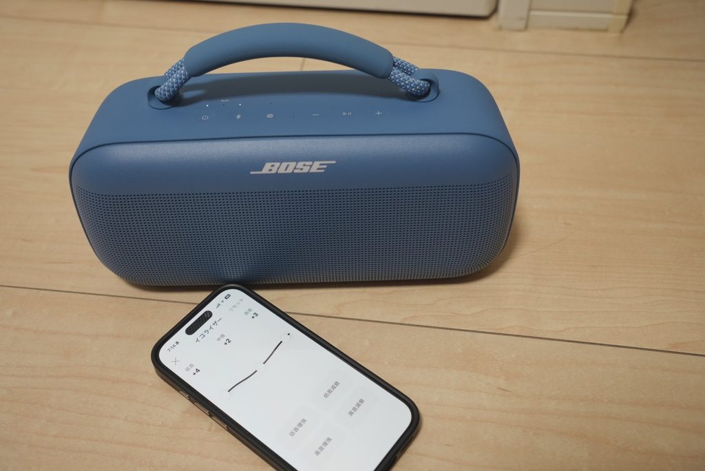 BOSE SoundLink Maxの前に置いたiPhoneで低音+4・中音+2・高音+3のイコライザー設定を表示している様子