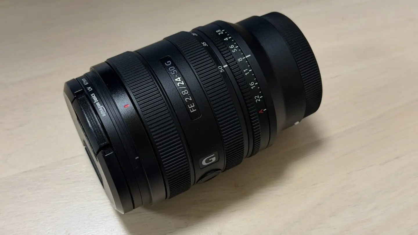 筆者所有のSONY FE 24-50mm F2.8 Gを木製テーブルに置いた実機写真